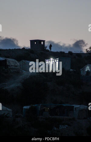 5 août 2018 - Khirbet Al-Jawz, zones rurales de Lattaquié, Syrie - Un soldat est vu debout à côté d'un mur de séparation entre la Syrie et la Turquie et est entouré de camps de personnes déplacées des zones de Lattaquié et ses alentours.La propagation des éléments de la gendarmerie turque sur la bande frontalière entre la Syrie et la Turquie. Credit : Muhmmad Al-Najjar/SOPA Images/ZUMA/Alamy Fil Live News Banque D'Images