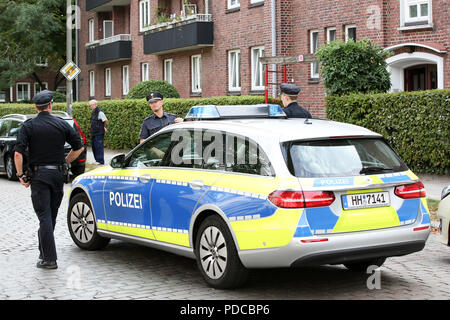 Hambourg, Allemagne. Le 08 août, 2018. Les agents de police sont debout devant un immeuble de Hamburg-Hamm où une jeune femme a été tuée. Apparemment, le père a tué sa fille, a déclaré un porte-parole de la police. Le suspect s'est enfui et a annoncé son suicide. Dans la recherche de l'homme suspect, un corps a été retrouvé à un poteau électrique dans Namur cet après-midi. Enquêtes sur son identité et l'historique de l'infraction poursuivie. Credit : Bodo Marks/dpa/Alamy Live News Banque D'Images