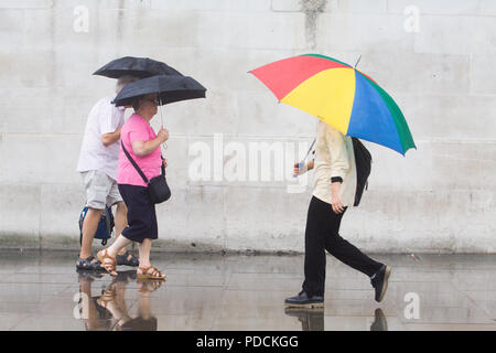London UK. 9 août 2018. Les piétons et les touristes brave la pluie à Trafalgar Square avec ponchos et parapluies par temps humide comme les pluies arrivent à briser le sort et l'été chaud Crédit canicule : amer ghazzal/Alamy Live News Banque D'Images