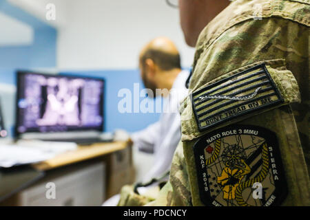 La PROVINCE DE KANDAHAR, Afghanistan (5 août 2018) -- La Marine américaine. Justin S. Clark, technicien en radiologie pour l'aérodrome de Kandahar l'OTAN L'Unité médicale multinationale de rôle III, les montres comme son homologue radiologie Afghan vérifie les résultats d'une radiographie, le 5 août 2018, au cours d'une visite de consultation médicale à l'hôpital militaire régional de Kandahar, Camp Hero à Kandahar, en Afghanistan. Les membres du personnel du rôle III Conduite des visites de routine dans KRMH à former et des conseils du personnel médical Afghan. (U.S. Photo de l'armée par le sergent. Neysa Canfield/TAAC-Sud Affaires publiques) Banque D'Images