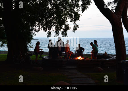 Les étudiants de l'Université de Chicago sont découpé sur le lac Michigan dans la soirée qu'ils réunissent autour d'un feu de camp sur Promontory Point. Banque D'Images