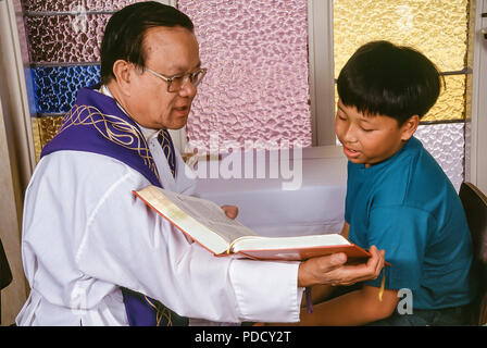 Young boy reading Bible de prêtre pendant la synchronisation. © Myrleen ....Pearson Ferguson Cate Banque D'Images