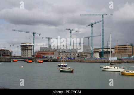 Les grues de construction pointant à l'horizon sur le côté nord de Dublin docklands. Banque D'Images