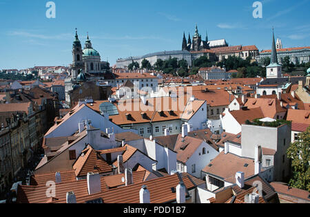 Ville de Prague avec vue sur les toits de tuiles rouges de l'église Saint-Nicolas et le château de Prague Banque D'Images