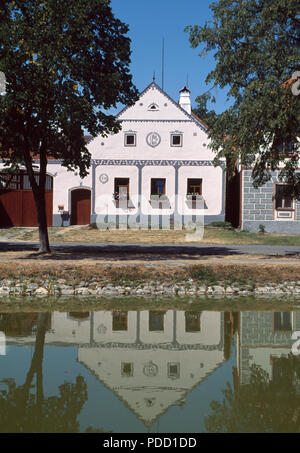 En face du canal de l'ancien bâtiment de la crème dans le village historique de Holasovice en Bohême du Sud en République Tchèque Banque D'Images