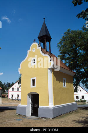 Chapelle peinte ocre dans le village historique de Holasovice en Bohême du Sud en République Tchèque Banque D'Images