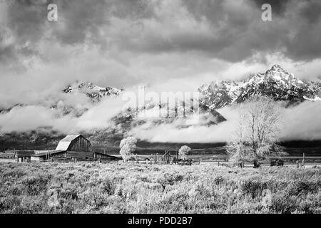 Teton Mountain Range avec Moulton Barn dans les nuages, Grand Teton National Park, Wyoming, USA. Banque D'Images