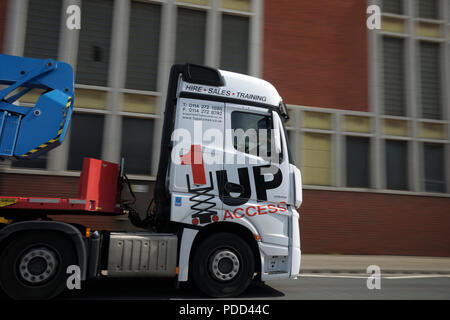 Mercedes-Benz Actros camion tirant une remorque avec grue passe par une usine sur une double voie urbaine Banque D'Images