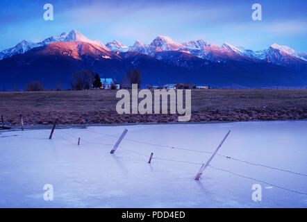 Ranch avec des montagnes au coucher du soleil, Montana, Mission Montagne Banque D'Images
