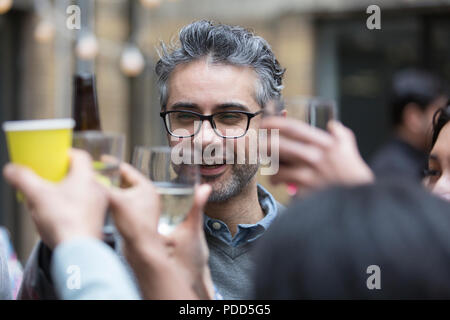 Happy man toasting drinks with at party Banque D'Images