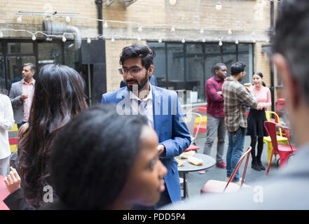 Les amis socializing at party on patio Banque D'Images