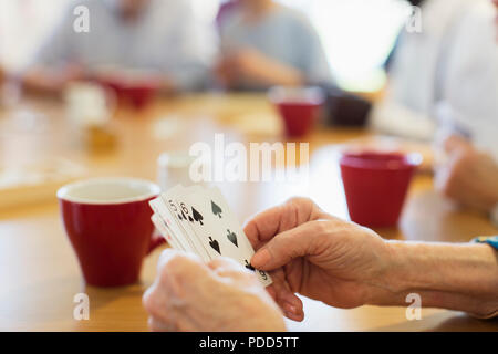 Close up senior woman jouer aux cartes avec des amis au centre communautaire Banque D'Images