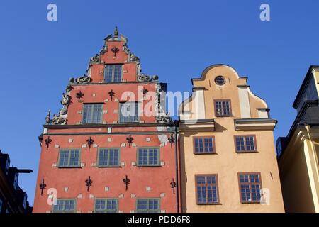 Deux maisons jaune et rouge dans la ville de Stockholm. Haut des bâtiments avec windows dans une journée ensoleillée sur une place de la ville. Banque D'Images