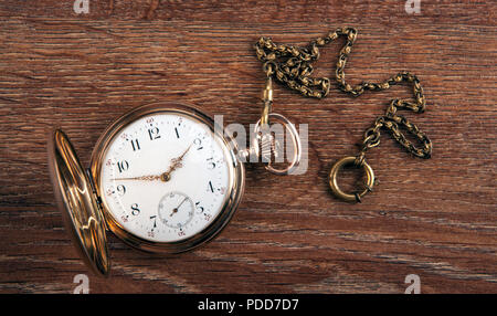 Une ancienne montre en or se trouve sur une table en bois Vue de dessus Banque D'Images