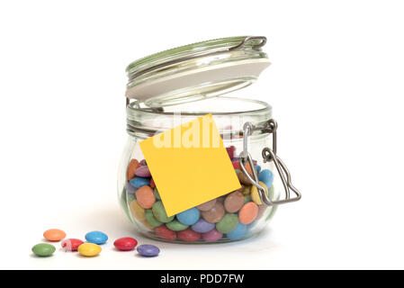 Bonbons bonbons de sucre coloré dans un bocal en verre avec clip top post-it jaune sur l'extérieur Banque D'Images