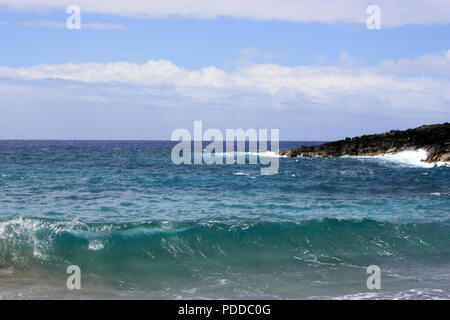 Une vague composée de multiples nuances de bleu de l'eau de mer dans une baie à Hawaii, USA Banque D'Images