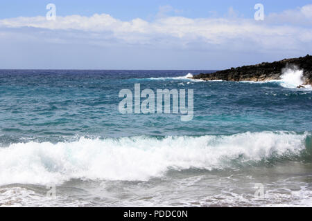 Une vague composée de multiples nuances de bleu de l'eau de mer dans une baie à Hawaii, USA Banque D'Images