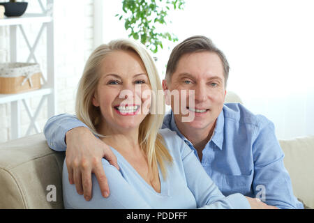 Couple à la maison sur le canapé de parler et de sourire. Libre Banque D'Images