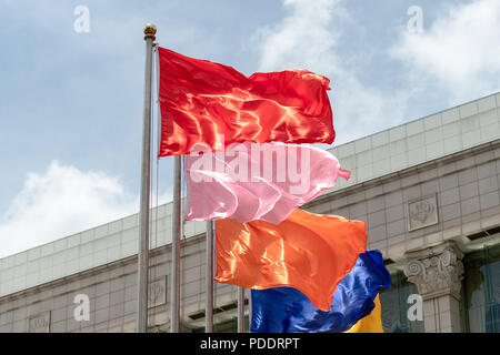 Collection de drapeaux de couleur différente à partir de poteaux en face d'un bâtiment Banque D'Images