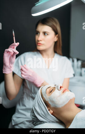 Coiffeur avec seringue dans les mains, botox injection Banque D'Images