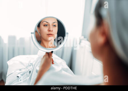 Patient regarde son visage à travers le miroir Banque D'Images