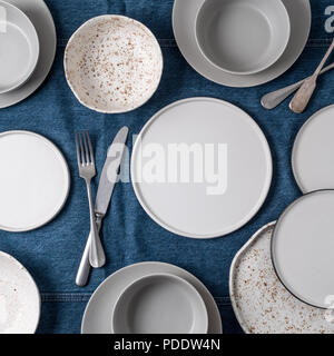 La vaisselle en céramique vide. Plaques en céramique sur un jean nappe ou des canaux chauds. Sommaire Tableau des aliments vides avec de la vaisselle. Définir des différentes assiettes et bols blanc moderne.Vue supérieure ou télévision lay.Copier l'emplacement pour un texte Banque D'Images