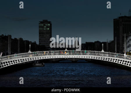 Ha'penny Bridge illuminé par la lumière avec la ville historique dans l'ombre créer un effet spectaculaire Banque D'Images