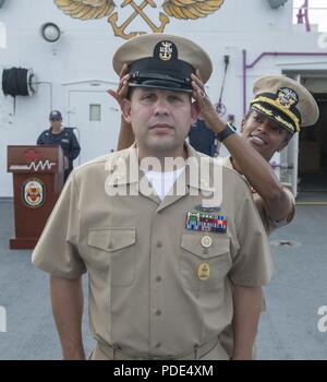 Océan (12 mai 2018) Master Chief Benito Encinias, affectés à la commande de transport maritime militaire navire-hôpital USNS Mercy (T-AH 19), reçoit de son maître le premier maître de combinaison de couvrir le capitaine Lynelle Boamah, Mercy's de la direction, au cours de sa cérémonie de promotion sur la Miséricorde de lancement. La miséricorde est actuellement déployé à l'appui de Partenariat du Pacifique à venir 2018 (PP18) Missions. PP18's mission est de travailler ensemble avec l'hôte et les pays partenaires à améliorer l'interopérabilité régionale et de capacités de réaction aux catastrophes, d'accroître la stabilité et la sécurité dans la région, et de favoriser de nouvelles et d'e Banque D'Images