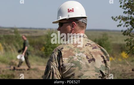 Maître de l'armée américaine le Sgt. Byron Smith, la construction de la paix sous-officier responsable des efforts de la construction aux États-Unis à Kielce, Pologne, Zone de formation est joint à la 107ème bataillon du génie, Michigan Garde Nationale comme il se rend dans un lieu de travail où des soldats ingénieur polonais chercher des munitions non explosées au cours de 2018, Château Ferme le 14 mai 2018. Resolute Castle est un exercice d'entraînement multinational pour l'OTAN et l'armée américaine des ingénieurs, qui prend en charge la résolution de l'Atlantique en favorisant l'interopérabilité. Résoudre l'Atlantique est une démonstration de l'engagement des États-Unis pour la collecte Banque D'Images