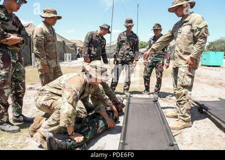 La CPS de l'armée américaine. Raymundo Sarabia, un médecin spécialiste de l'Administration centrale et de l'Administration centrale, l'entreprise 1er Bataillon, 21e Régiment d'infanterie, 2e Brigade Combat Team, 25e Division d'infanterie, montre ses homologues de l'Armée Philippine's 72e compagnie de reconnaissance de la Division, 7e Division d'infanterie, la façon de préparer et de charger une victime sur une portée en prévision d'une évacuation sanitaire au cours de l'exercice Balikatan, au Colonel Ernesto Ravina Air Base, Tarlac, Philippines, le 13 mai 2018. Exercice Balikatan, dans sa 34e version, est un américain annuel-exercice d'entraînement militaire des Philippines est concentré sur Banque D'Images