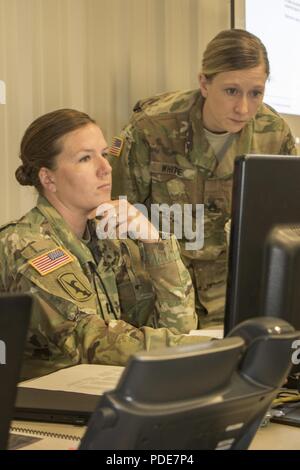 Le capitaine Marieke Baughman, chef d'équipe, et le sergent. Stephanie White, sous-officier du renseignement, discuter d'une menace potentielle, le mercredi 16 mai au Camp Atterbury, Ind., pendant 18 Cyber Shield. Bouclier 18 Cyber Army National Guard est un exercice visant à évaluer les plans d'intervention sur les Guerriers de cyberincidents et dispose de plus de 800 soldats et aviateurs. Banque D'Images