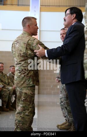 Le lieutenant-gouverneur du Dakota du Sud. Matt Michels félicite et salue le capitaine de l'armée américaine accueil Jared Bloomgren, d'un déploiement de neuf mois avec le Dakota du Sud de l'Army National Guard 216e détachement du génie (lutte contre les incendies) de l'équipe de Rapid City, S.D., 16 mai 2018. Bloomgren, commandant de la 216e, engagée aux côtés de Sgt. 1re classe Austin Hagen, chef des pompiers, et le sergent. Robert Robertson, inspecteur des incendies, où ils ont fourni le commandement et le contrôle des équipes de lutte contre les incendies en Roumanie et Bulgarie. Banque D'Images