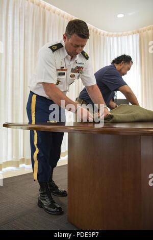 Le sergent de l'armée américaine. 1re classe Nathan Austin, gauche, et Larry Magaoay, Casualty Assistance Centre coordonnateur affaires mortuaires, fixer le reste du U.S. Army Air Forces slt Clarence E. Allen, un cousin de Austin's, pour le transport au cours d'une chaîne de traçabilité à l'événement le sénateur Daniel K. Inouye Centre d'excellence sur Joint Base Harbor-Hickam Pearl, Mississippi, le 18 mai 2018. Austin a visité la défense POW/MIA Agence Comptable (DPAA) dans le cadre de ses fonctions de l'escorte de l'armée américaine spécial pour son cousin's reste en route vers le lieu de sépulture de Allen dans le Cimetière National d'Arlington. Allen, un P-47 Banque D'Images