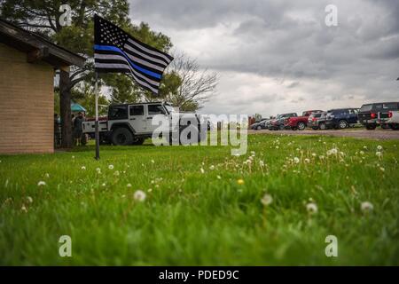 La mince ligne bleue d'un drapeau de vagues dans le vent lors d'un barbecue pour la clôture de la Semaine de la police, le 18 mai 2018, sur F.E. Warren Air Force Base, Wyo. la Semaine de la police a conclu avec les festivités pour les aviateurs et les familles pour se détendre après une semaine d'événements et de travail. En 1962, le président John F. Kennedy a signé une proclamation qui a désigné le 15 mai comme Journée de commémoration des agents de la paix et de la semaine où cette date tombe comme la Semaine de la police. Toutes les personnes à travers les États-Unis participent à divers événements qui honorer ceux ont fait le sacrifice ultime. Banque D'Images