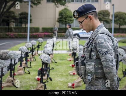 Un aviateur affecté à la 374e Escadron des Forces de sécurité s'incline la tête au cours d'une prière pour les morts les membres de l'application de la loi au cours d'une cérémonie commémorative de la Semaine de la police, le 18 mai 2018, à Yokota Air Base, le Japon. La Semaine nationale de la police accorde une reconnaissance aux responsables de l'application des lois qui ont perdu leur vie dans l'exercice de leurs fonctions pour la sécurité et la protection des autres. Banque D'Images
