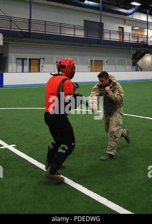 1er lieutenant Gregory, RQ-4 Global Hawk pilote avec le 69e Groupe de Reconnaissance, droit, s'applique aux cadres techniques de combat Airman Jeren Grantham, simulation d'auteur et de l'instructeur avec le 319e Escadron des Forces de sécurité, au cours d'une compétition de préparation, le 18 mai 2018, à Grand Forks Air Force Base, dans le Dakota du Nord. Le combat corps à corps a été l'une des nombreuses stations sur la compétition, les équipes de test d'unités à travers la base de leurs connaissances et l'application des connaissances. Banque D'Images