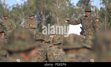 U.S. Marine SSgt Brandon Bardos, 2e Bataillon, 4e compagnie de marines, sergent du peloton F 3e donne les marines des actions individuelles sur la façon d'améliorer et de construire à partir de ce qu'ils ont fait du bon tout en participant à Ex-Warfighter sur Shoal Water Bay Domaine de formation, l'Australie, le 20 mai 2018. Ex-combattants est une partie de la Force de défense australienne une formation pour être en mesure de déployer. Banque D'Images