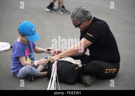 Chris Fucci, des Para-Commandos, enseigne un enfant comment à l'age d'un parachute au cours de Marine Le Pen de Tampa Bay en 2018 à la base aérienne MacDill, Floride, le 11 mai 2018. Les Para-Commandos sont volontaires dans U.S. Special Operations Command qui passent leur temps libre à perfectionner leurs compétences et en public. Banque D'Images