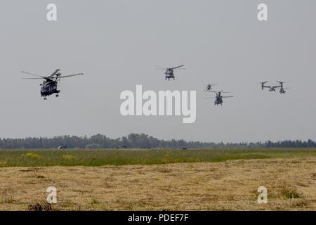 Un Corps des Marines MV-22 Osprey vole en formation avec hélicoptères italien à l'événement culminant de Joint Stars, un exercice d'entraînement bilatéral avec les forces militaires italiennes et des Marines des États-Unis, à Decimomannu, Sardaigne, le 18 mai 2018. But spécial Groupe Force-Crisis Response-Africa air-sol marin déployés pour effectuer d'intervention en cas de crise et théâtre-opérations de sécurité en Europe et l'Afrique. Banque D'Images