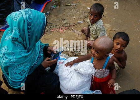 Un Rohingya nouvellement arrivés femme utilise votre téléphone mobile en avant du Camp de Réfugiés de Kutupalong. Cox's Bazar, Bangladesh Banque D'Images