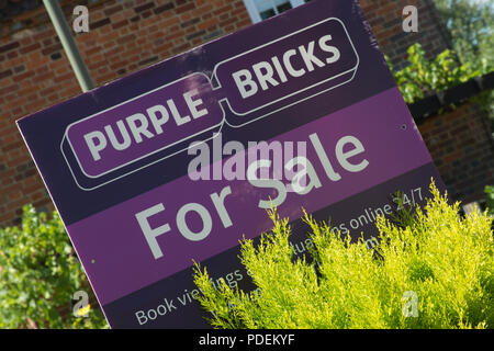Briques violet pour l'agent immobilier vente enseigne à l'extérieur d'une maison à Surrey, UK Banque D'Images