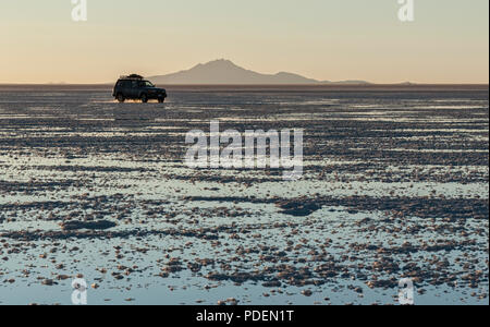 Location de hors-route dans le Salar de Uyuni pendant le coucher du soleil. C'est le plus grand de sel dans le monde - Site du patrimoine mondial de l'Altiplano, Bolivie Banque D'Images