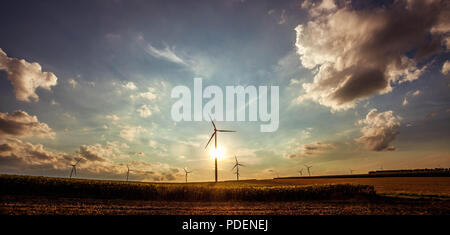 Beau paysage rural avec des silhouettes de générateurs d'énergie éolienne à l'horizon. Tonique. Banque D'Images