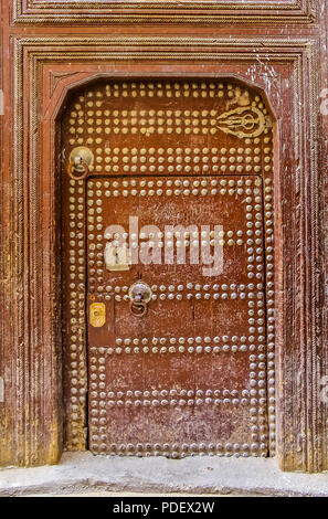 Ancienne en bois finement sculptée, porte cloutée et porte cadre,d'une maison marocaine traditionnelle à Fes, Maroc Banque D'Images