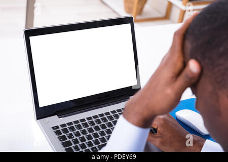 Portrait Of Businessman Looking At stressant écran blanc vide dans le bureau Banque D'Images