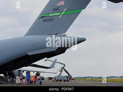 Une famille à pied vers un C-17 Globemaster III au cours de la Journée des Forces armées à Joint Base Lewis-McChord, dans l'État de Washington, 19 mai 2018. Les clients n'étaient en mesure de voir des expositions statiques d'avions militaires et de véhicules, manèges, carnival ride voir une reconstitution historique, visiter un zoo pour enfants et plus au cours de l'événement. Banque D'Images