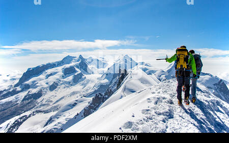 Deux alpinistes survey les montagnes environnantes tandis que sur l'oblique du Breithorn en Suisse Banque D'Images