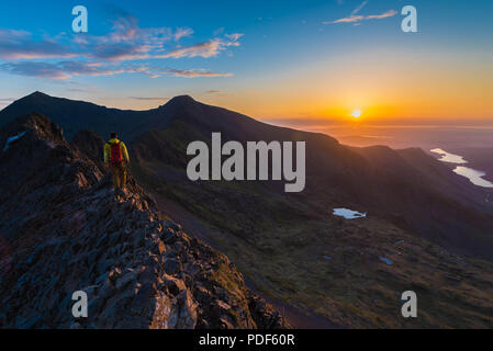 Mountaineer dans coucher de soleil sur lit d'Goch avec Snowdon dans l'arrière-plan Banque D'Images