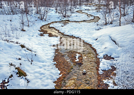 Petit-ruisseau, réchauffé par des sources géothermiques dans la région de Geysir, serpente à travers un paysage d'hiver enneigé en Islande Banque D'Images