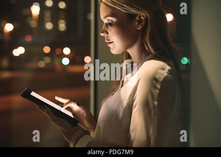 Close up of young businesswoman working on laptop in office. Belle femme travaillant tard nuit à l'office. Banque D'Images